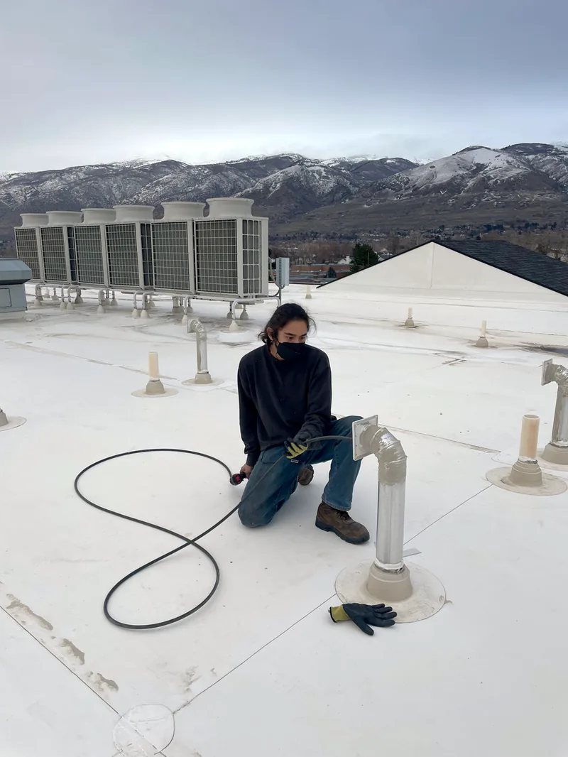 Technician servicing a rooftop dryer vent